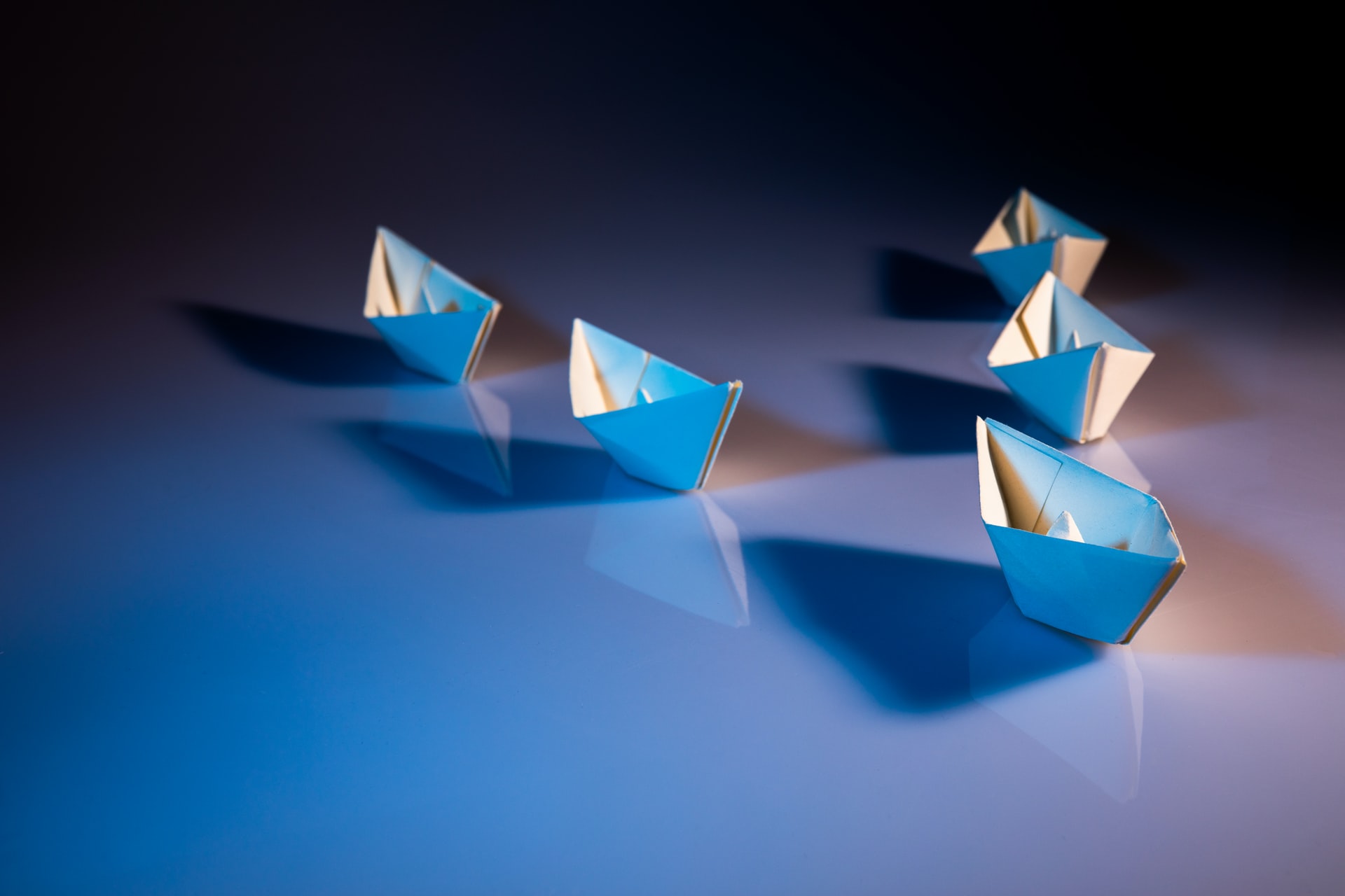 Barcos de papel em formação de liderança triangular